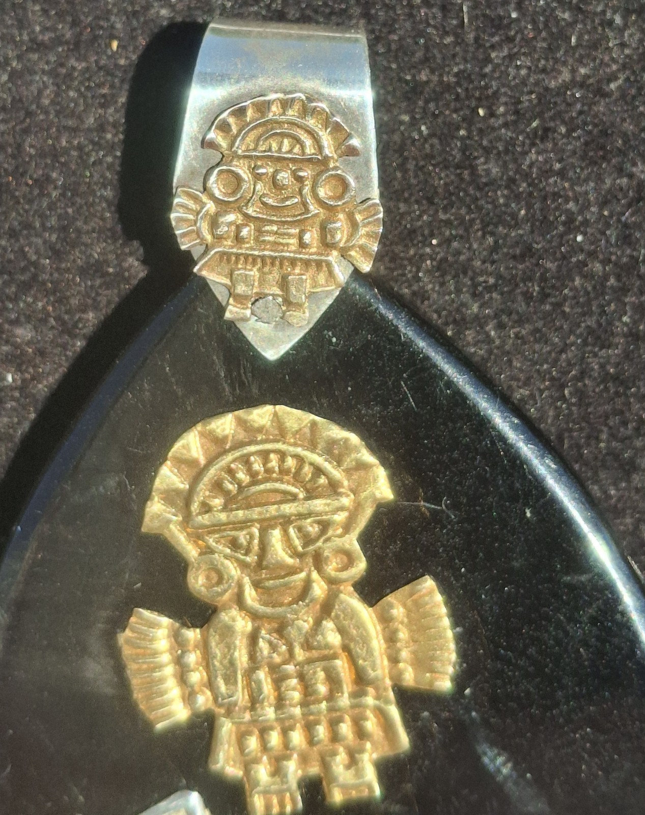 Vintage 18k gold & 925 Peruvian Tumi Deity Pendant on black plastic.