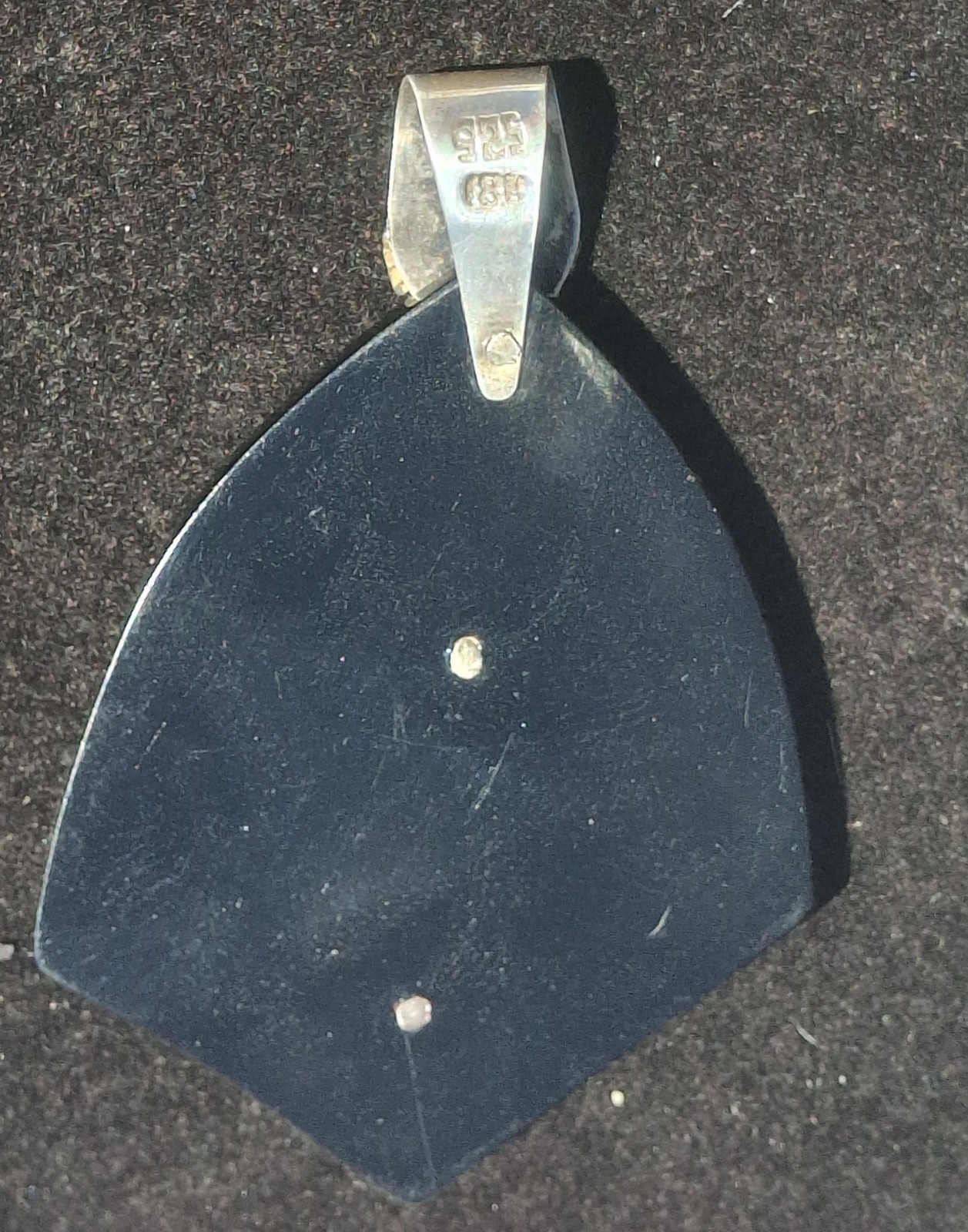 Vintage 18k gold & 925 Peruvian Tumi Deity Pendant on black plastic.