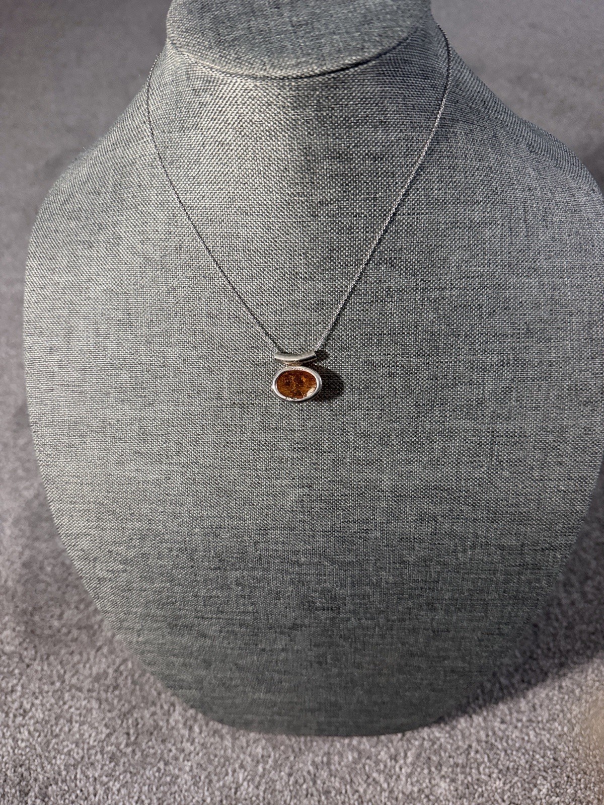 vintage-style oval Baltic amber pendant is set in .925 sterling silver with a di