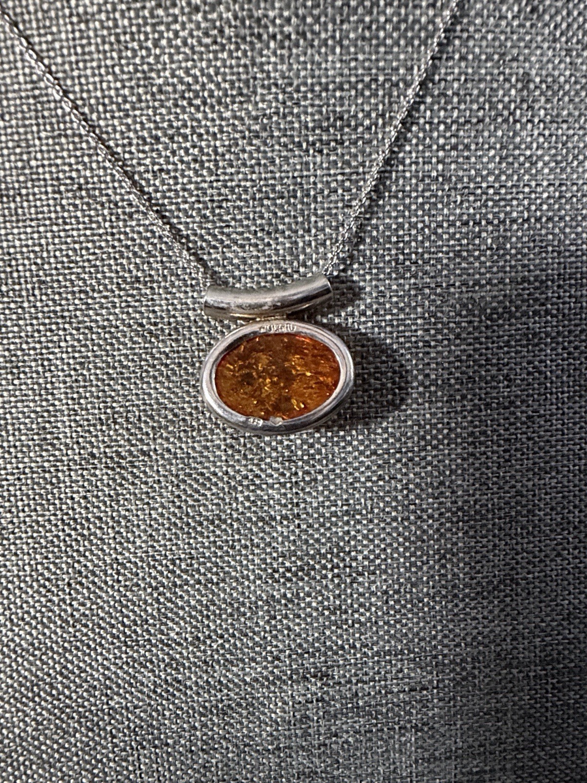 vintage-style oval Baltic amber pendant is set in .925 sterling silver with a di