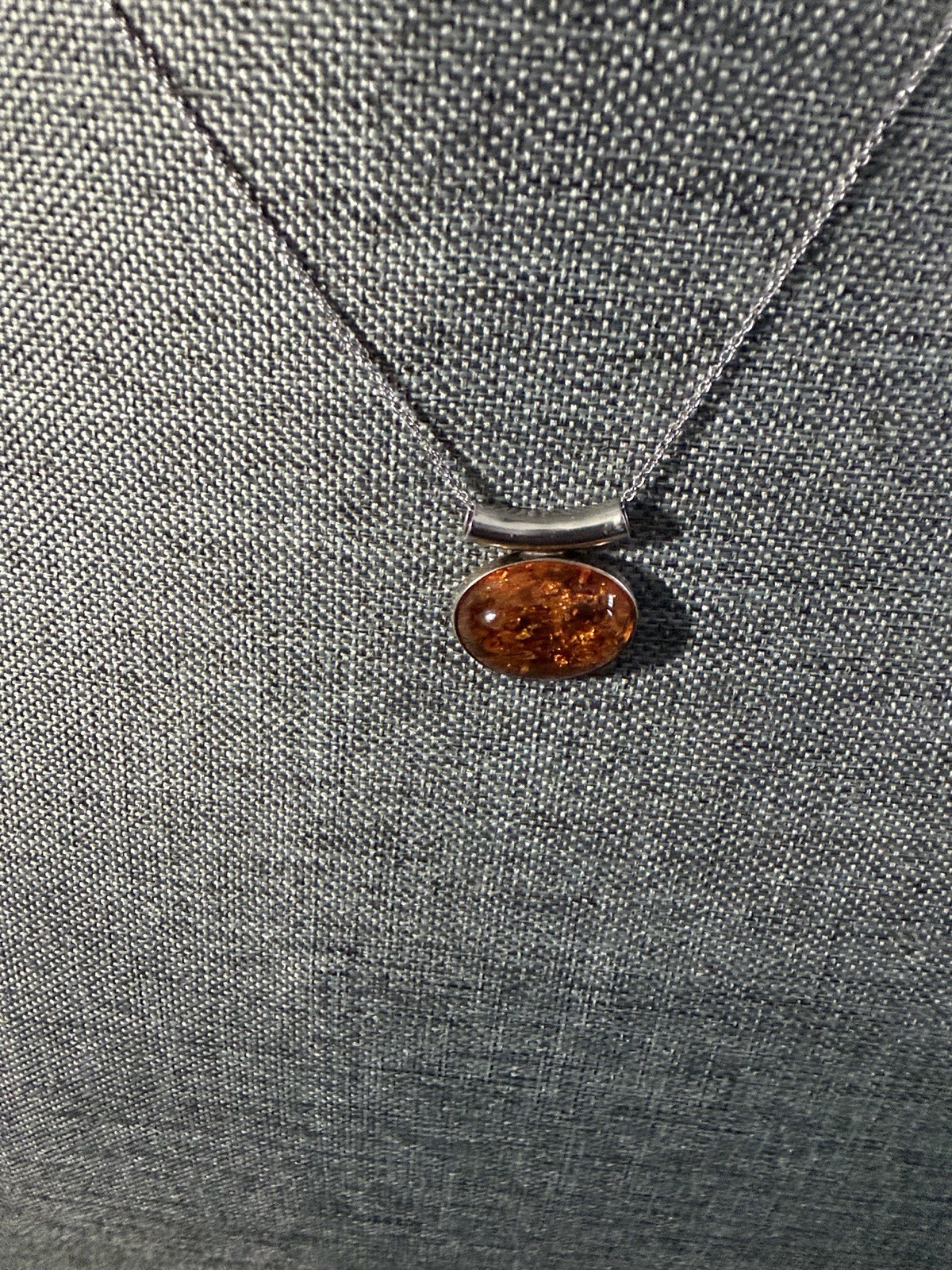 vintage-style oval Baltic amber pendant is set in .925 sterling silver with a di