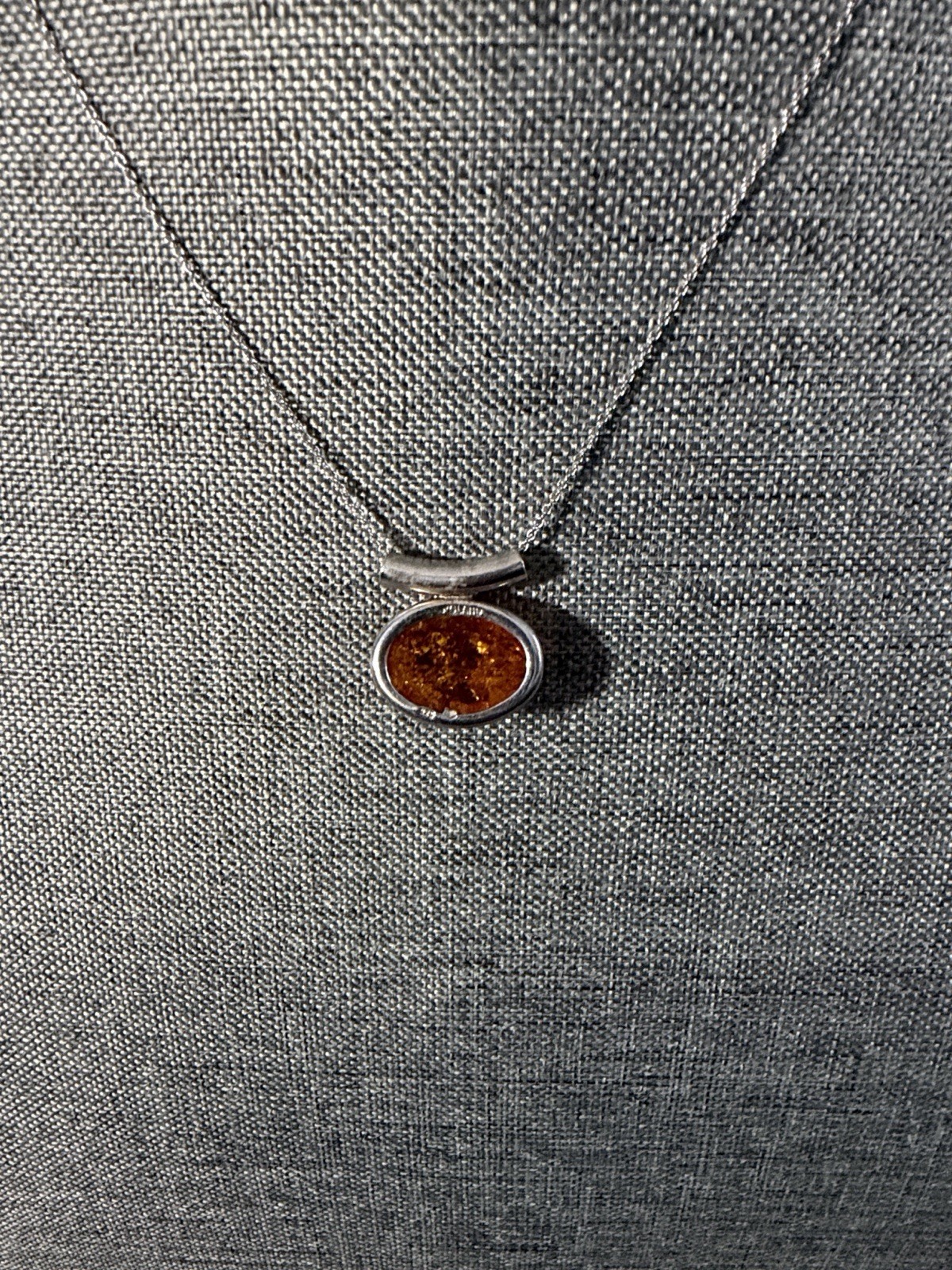 vintage-style oval Baltic amber pendant is set in .925 sterling silver with a di
